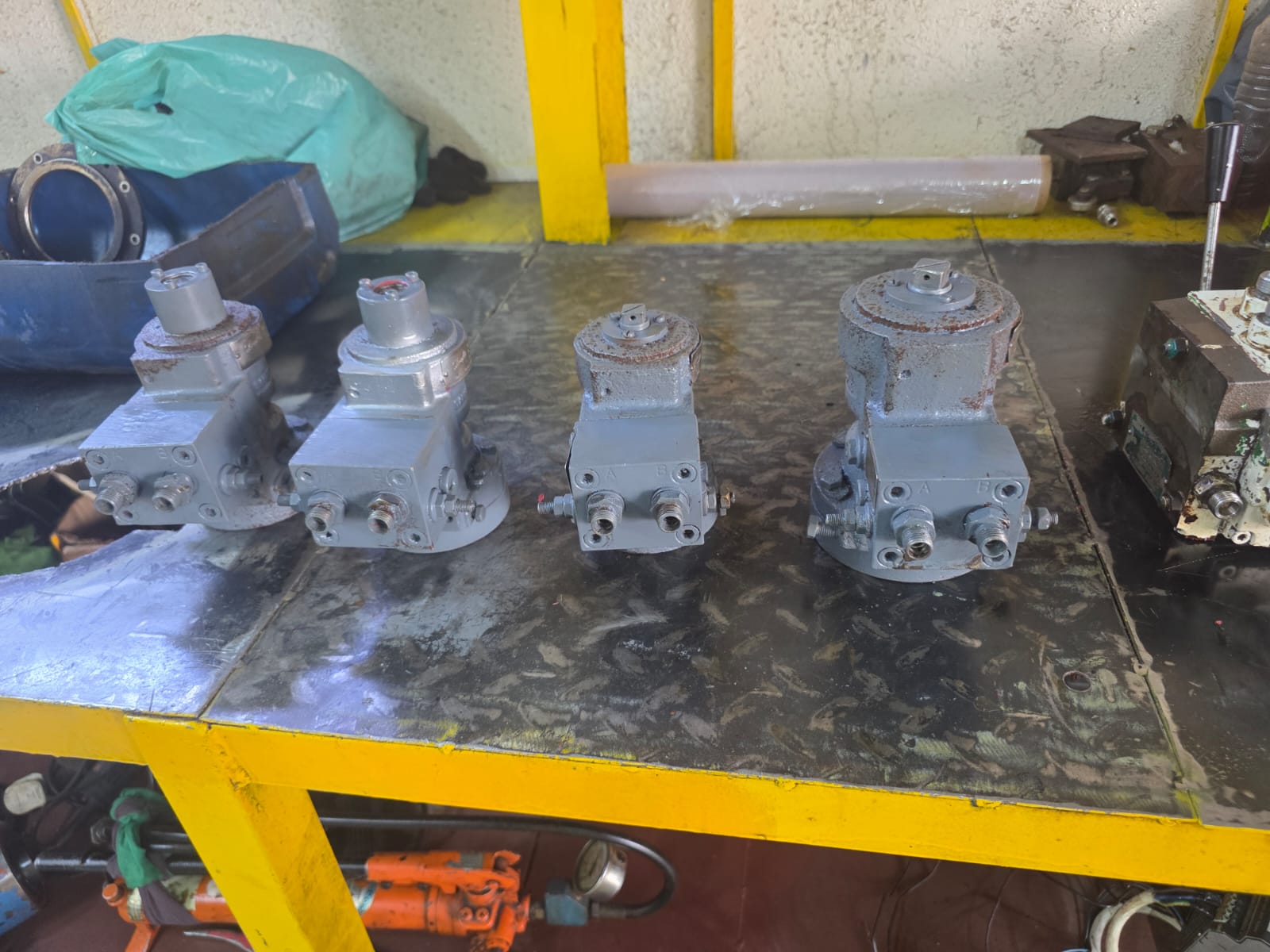 Four hydraulic actuator valve assemblies on the workbench