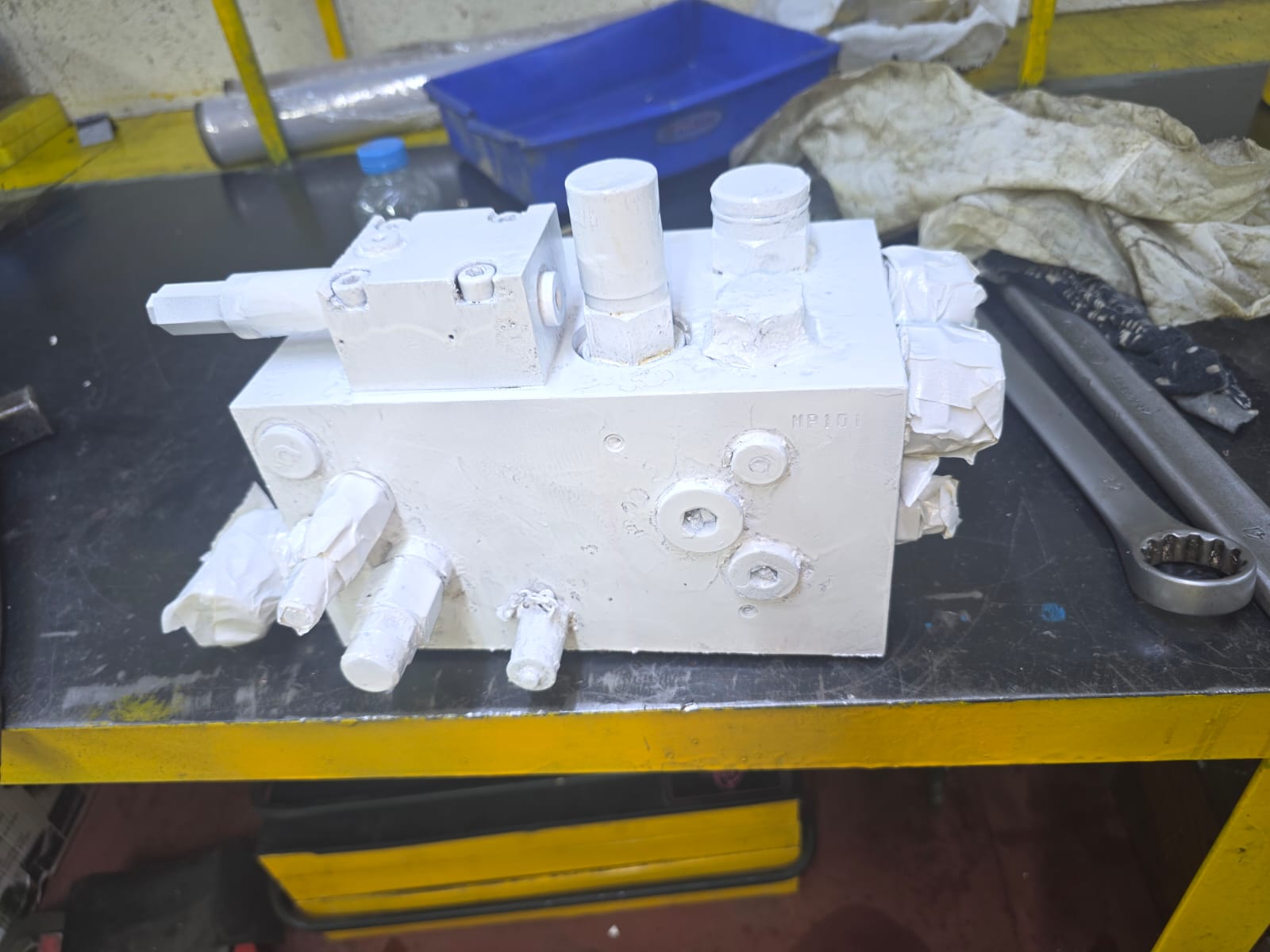 White hydraulic control valve on a workbench